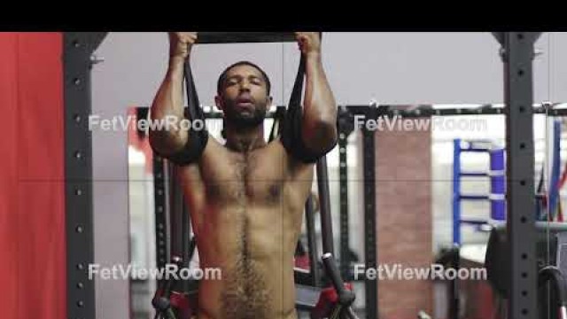 'Naked black man exercising in the gym.'